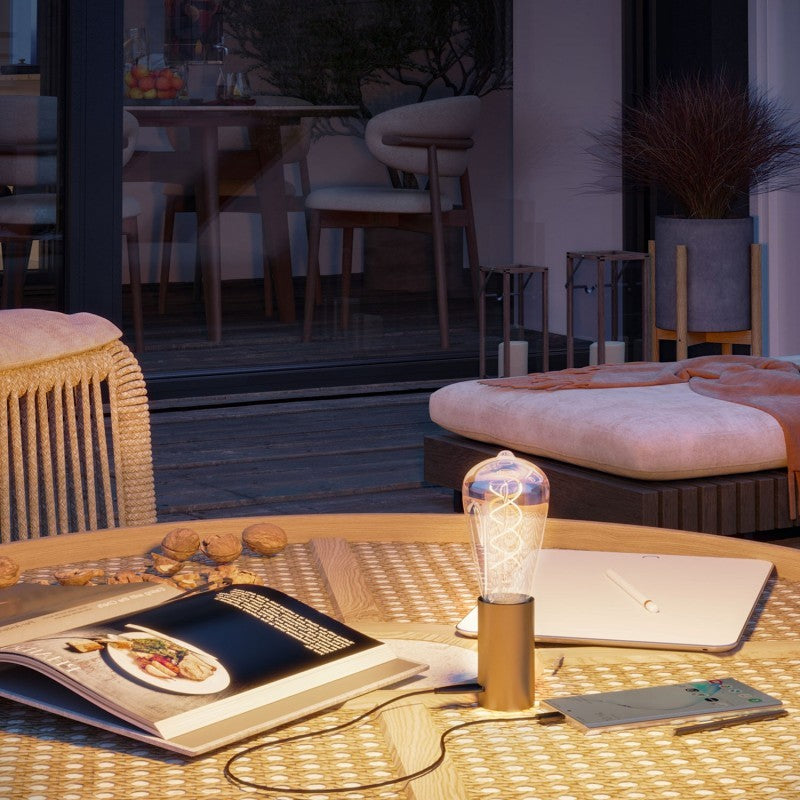 Tischlampe SI! Portable in Bronze satiniert neben einem Laptop