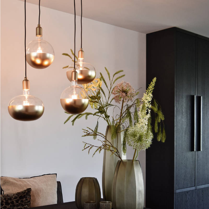 Calex LED-Leuchtmittel mit Kopfspiegel in Gold matt als Pendelgruppe vor dunkler Wand
