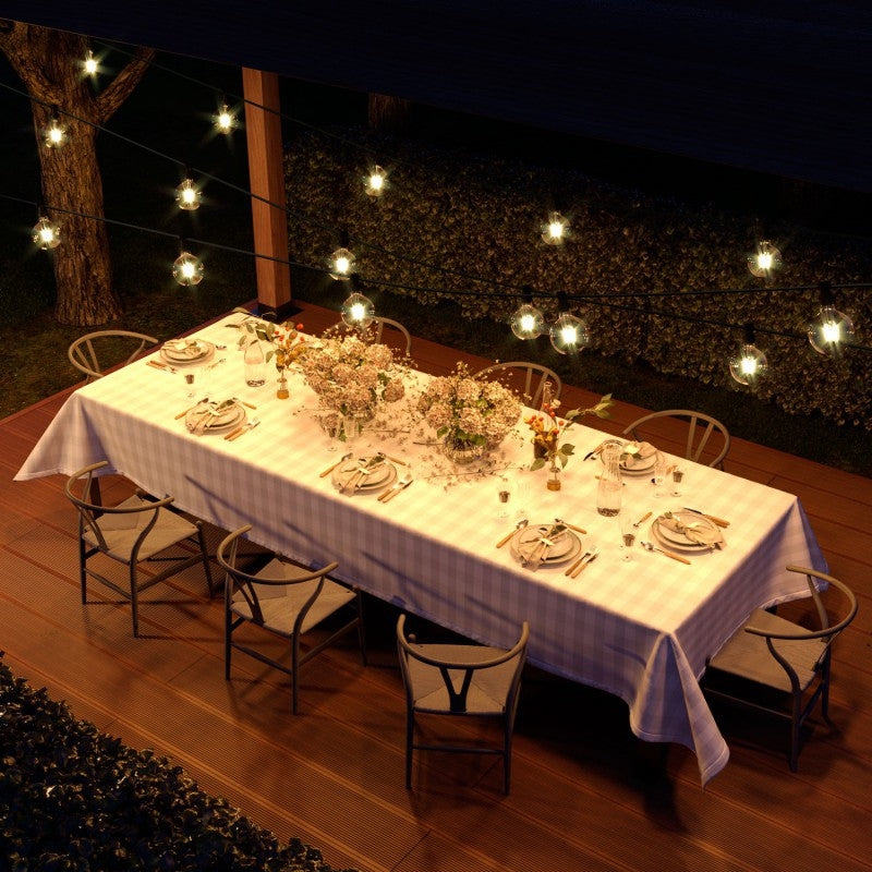 Lichterkette mit schwarzem Textilkabel über einer gedeckten Tafel am Abend